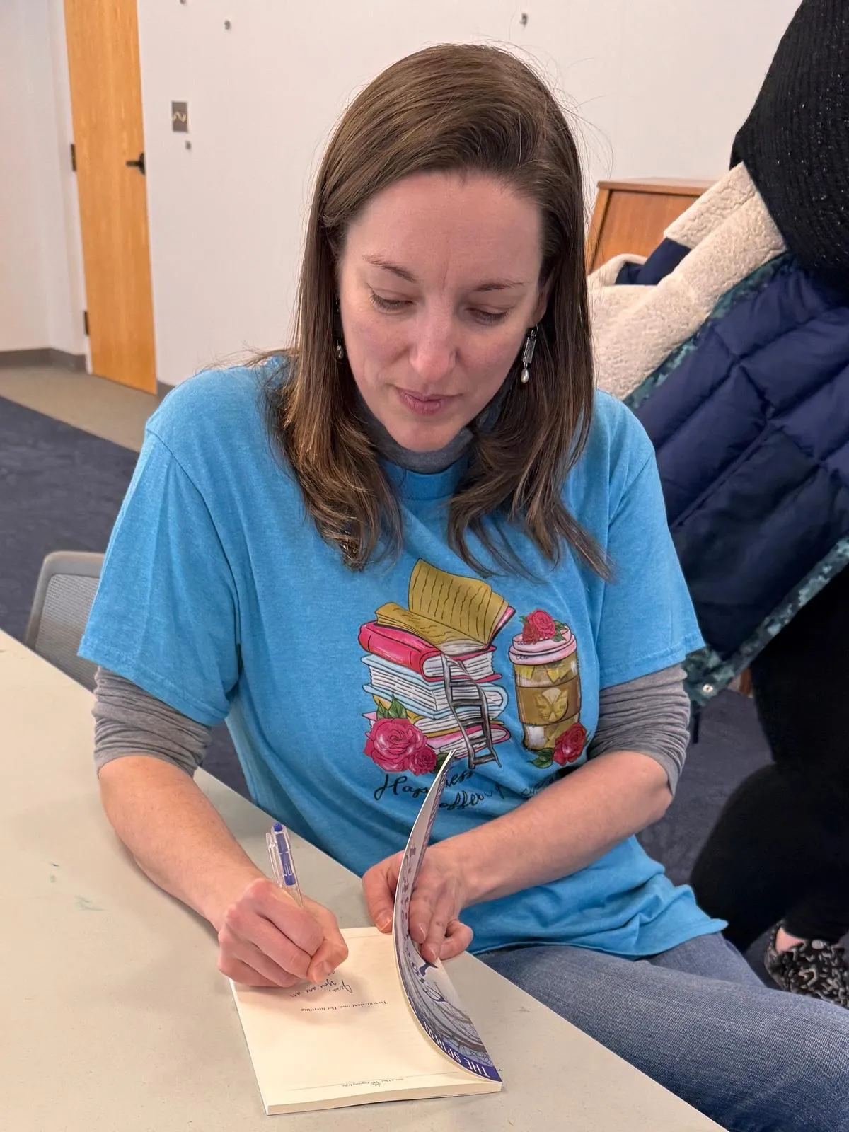 Jessica signing a copy of her poetry collection at a reading